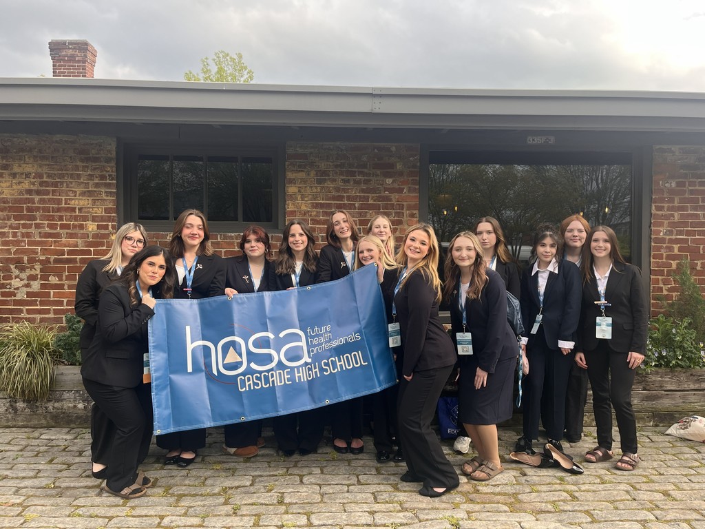 HOSA students pose for a group picture while holding a HOSA banner.