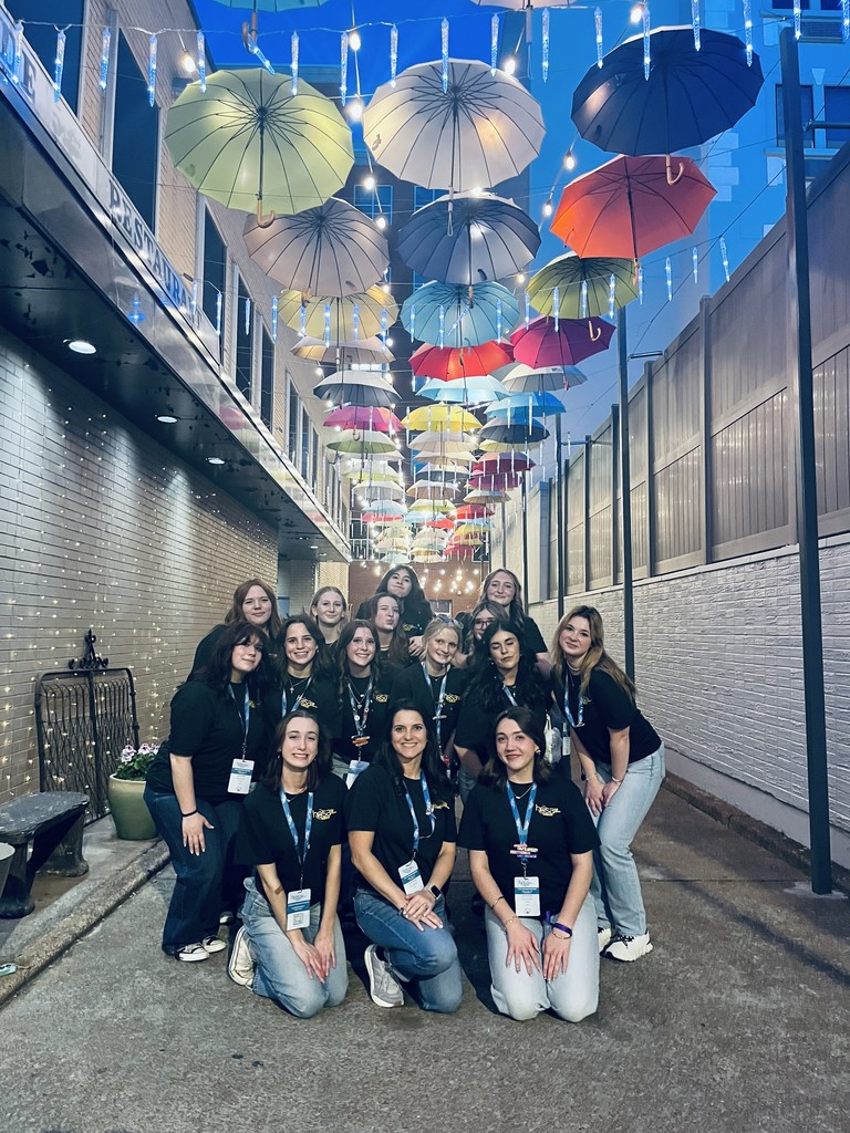 HOSA students pose for a picture underneath umbrellas hanging from the ceiling.