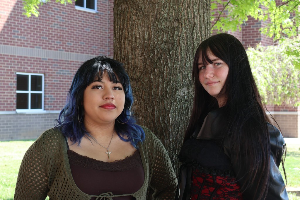 Two students standing in front of a tree posing for a picture.