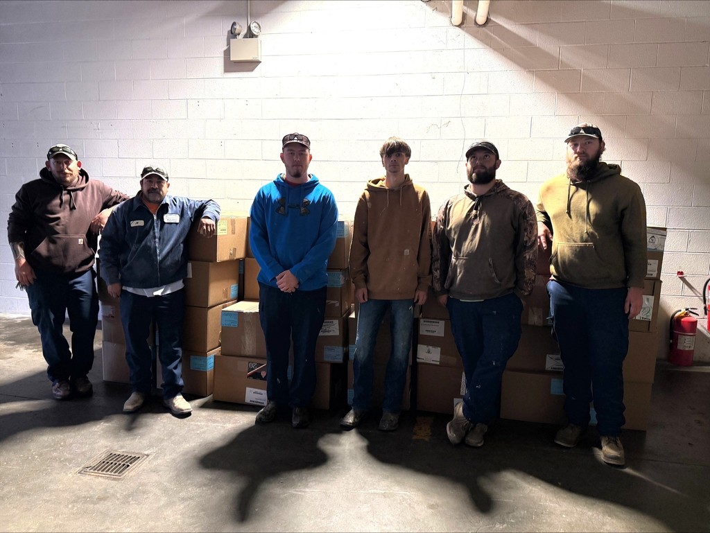 Group of people standing in front of food boxes that were packed for spring break.