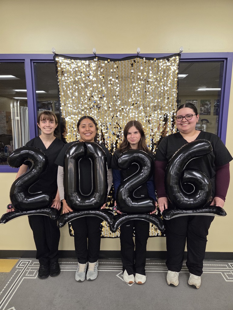 Group photo of four students holding balloons that say "2026".