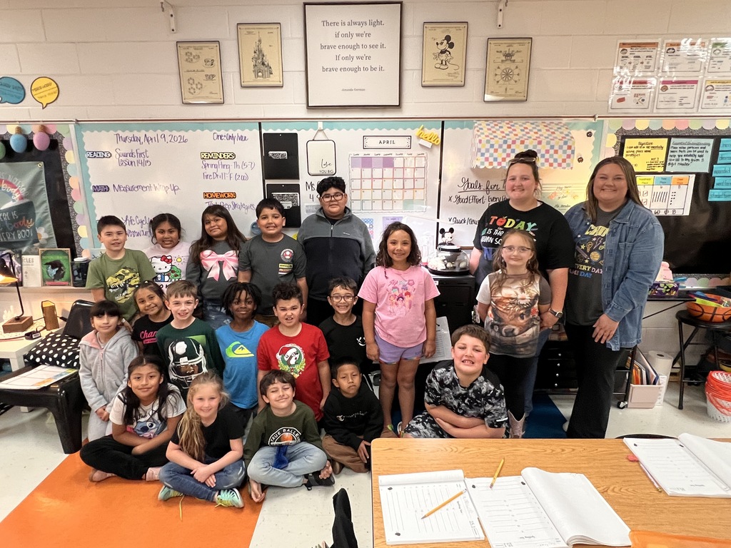 The students and their teacher and aide pose for a group picture. 