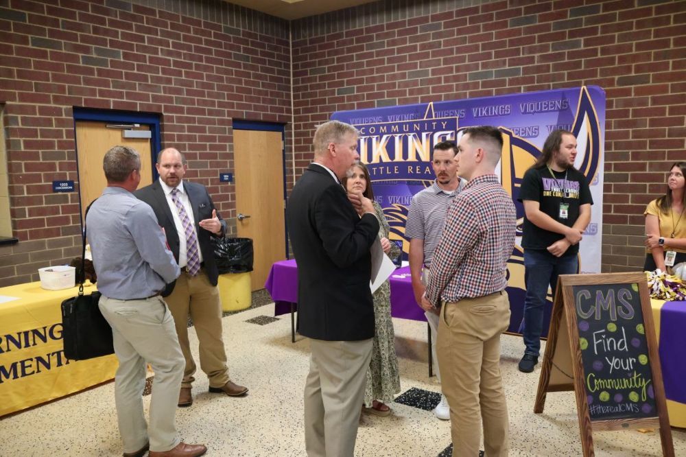 Administrators speaking with person at Teacher Recruitment Fair.