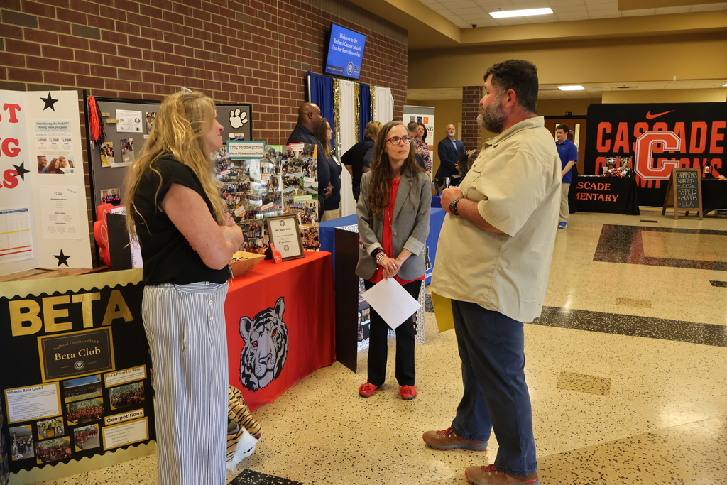 Administrators speaking with person at Teacher Recruitment Fair.