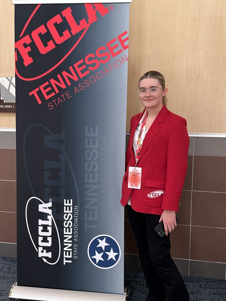 Student is posed next to an FCCLA TN State Association sign for a picture.