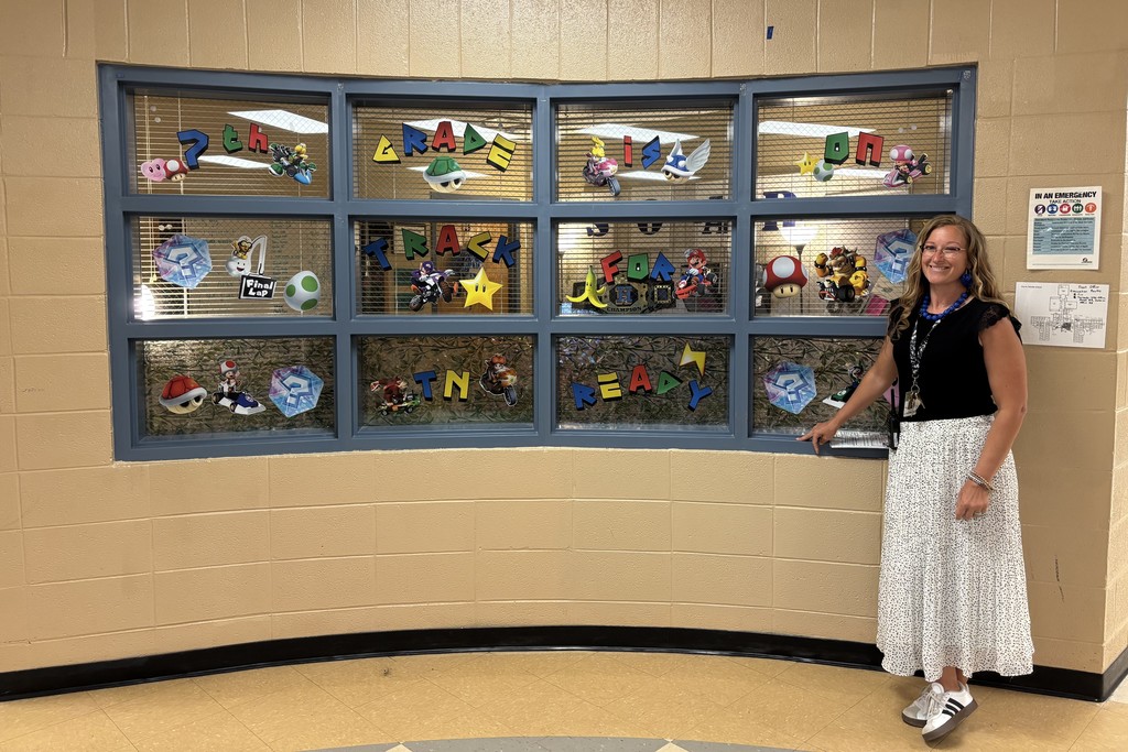 An admin member stands in front of some windows that are decorated for TCAP.