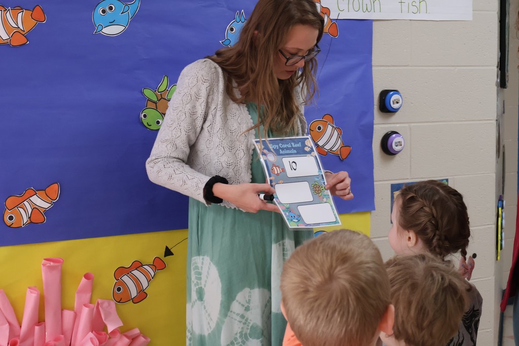 Students and their teacher are looking at the interactive coral reef exhibit at Eakin Elementary school. 