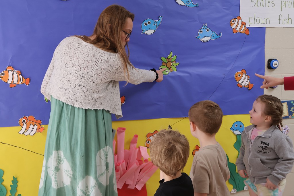 Students and their teachers are looking at the interactive coral reef exhibit at Eakin Elementary school. 