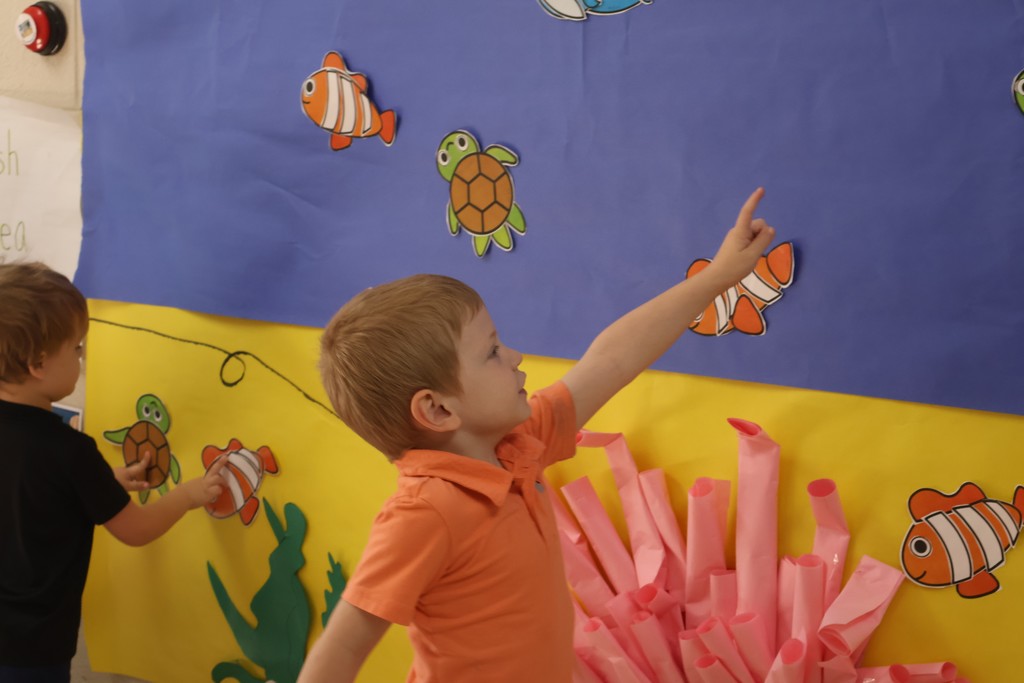 Students are looking at the interactive coral reef exhibit at Eakin Elementary school. 