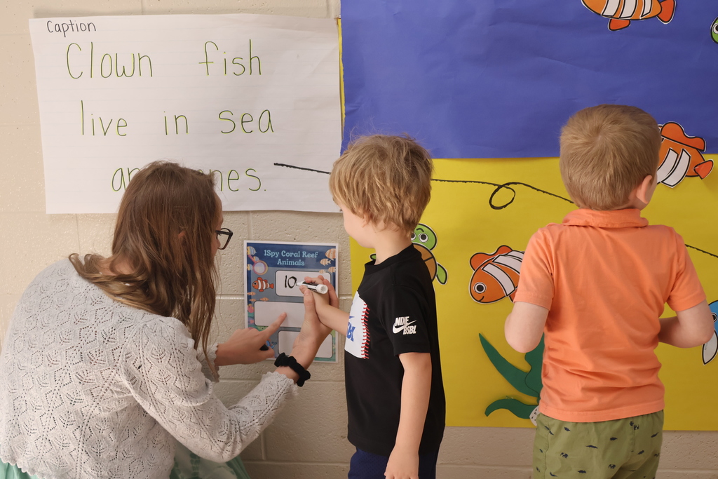 Students and their teacher are looking at the interactive coral reef exhibit at Eakin Elementary school. 