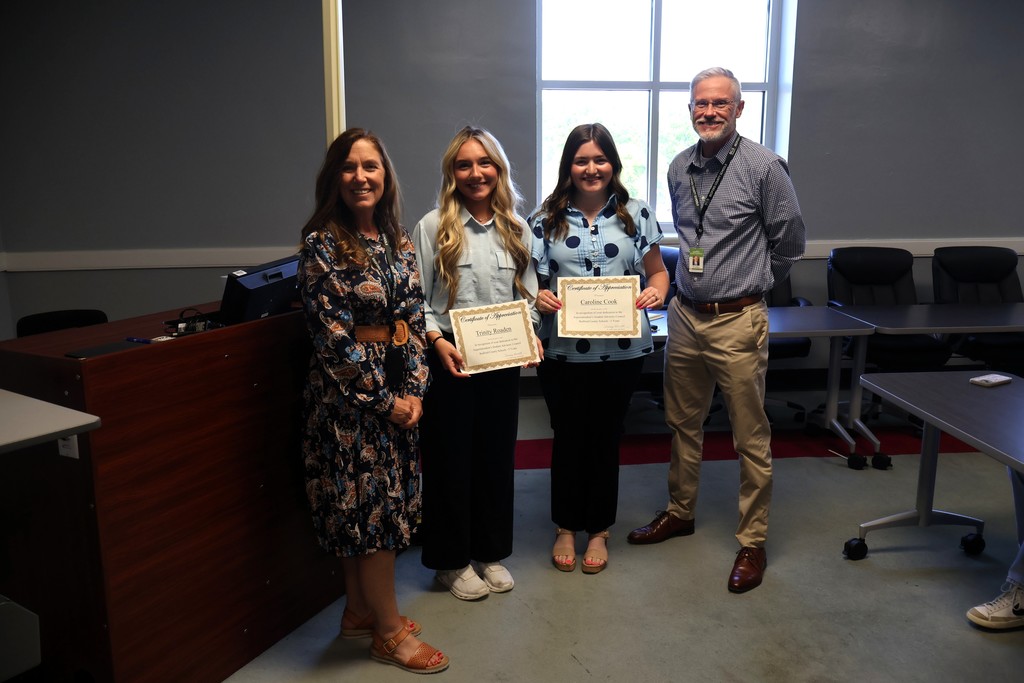 Two students are standing with the Superintendent Dr. Tammy Garrett and Assistant Superintendent Tim Harwell. 