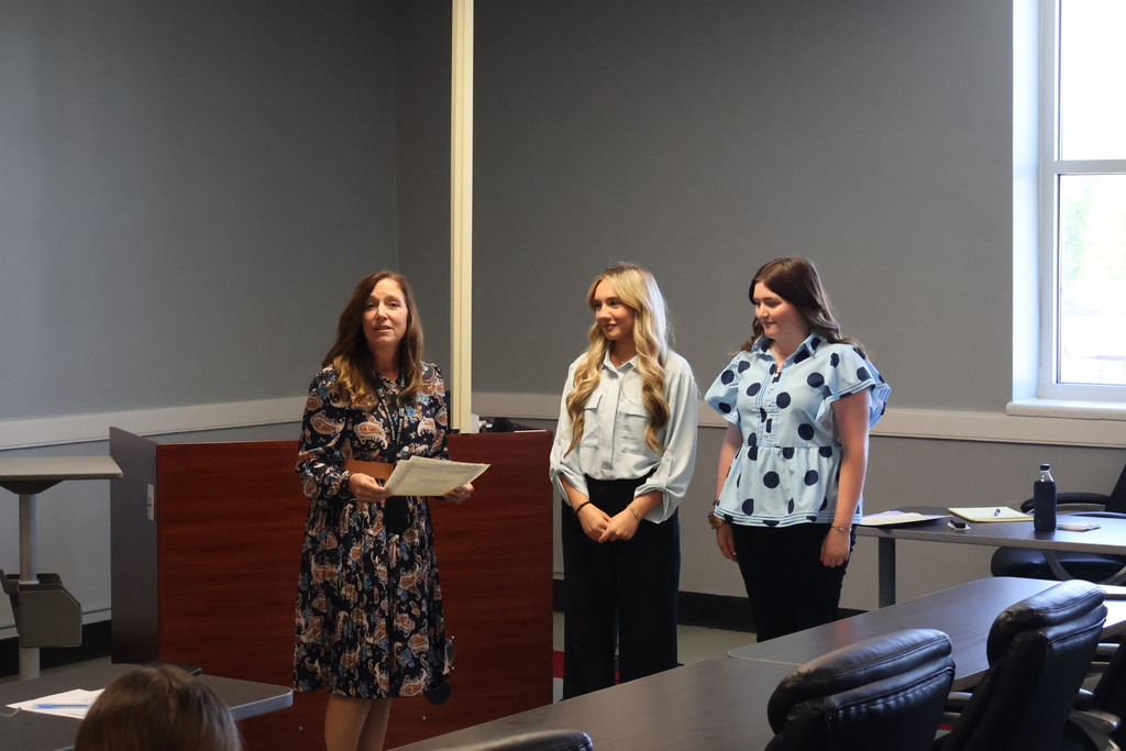 Students are standing with the Superintendent Dr. Tammy Garrett who is holding certificates for each one. 