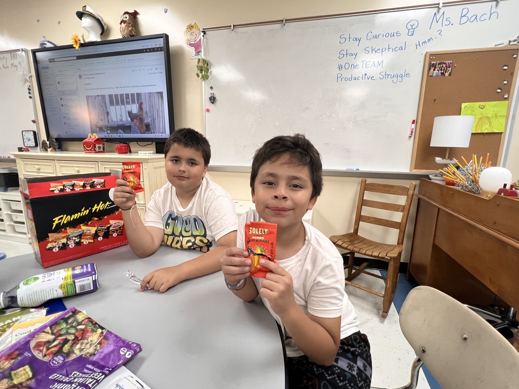 Students hold up a food that they are about to taste.