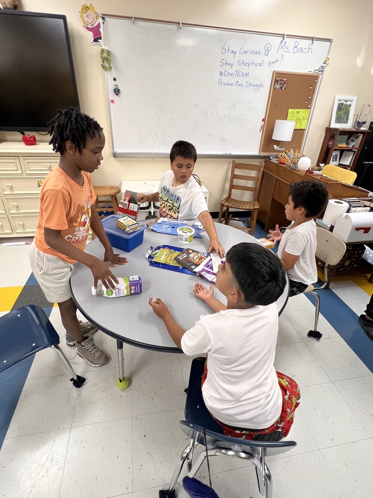 Students are sitting at tables learning about healthy foods.