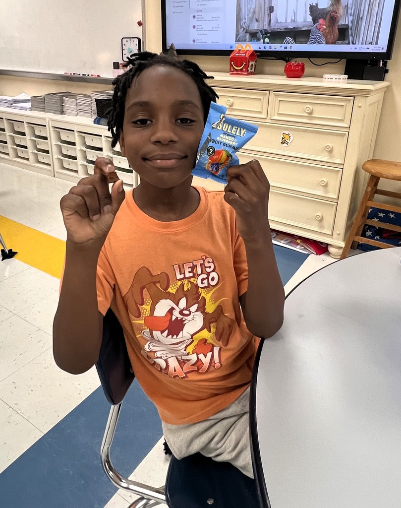 A student holds up a food that he is about to taste.