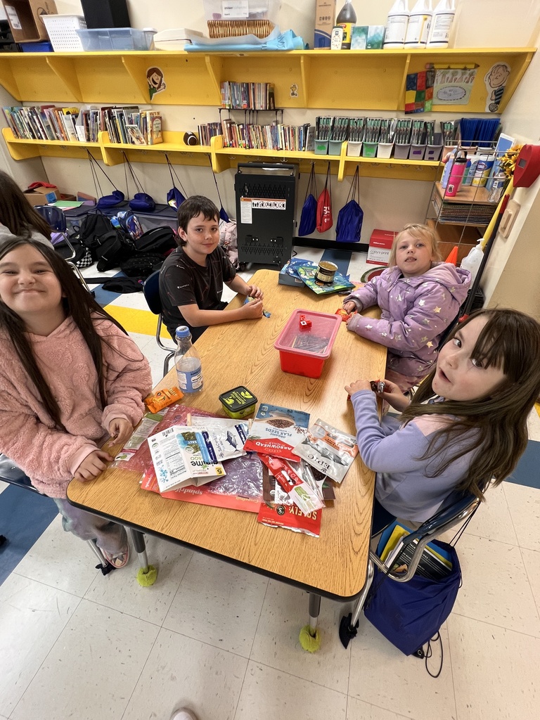 Students are sitting at tables learning about healthy foods.