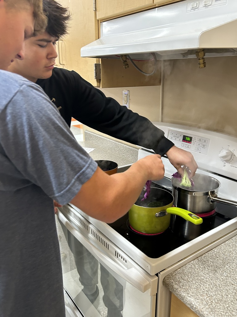 Culinary Arts II students are cooking vegetables in different solutions on the stove. 