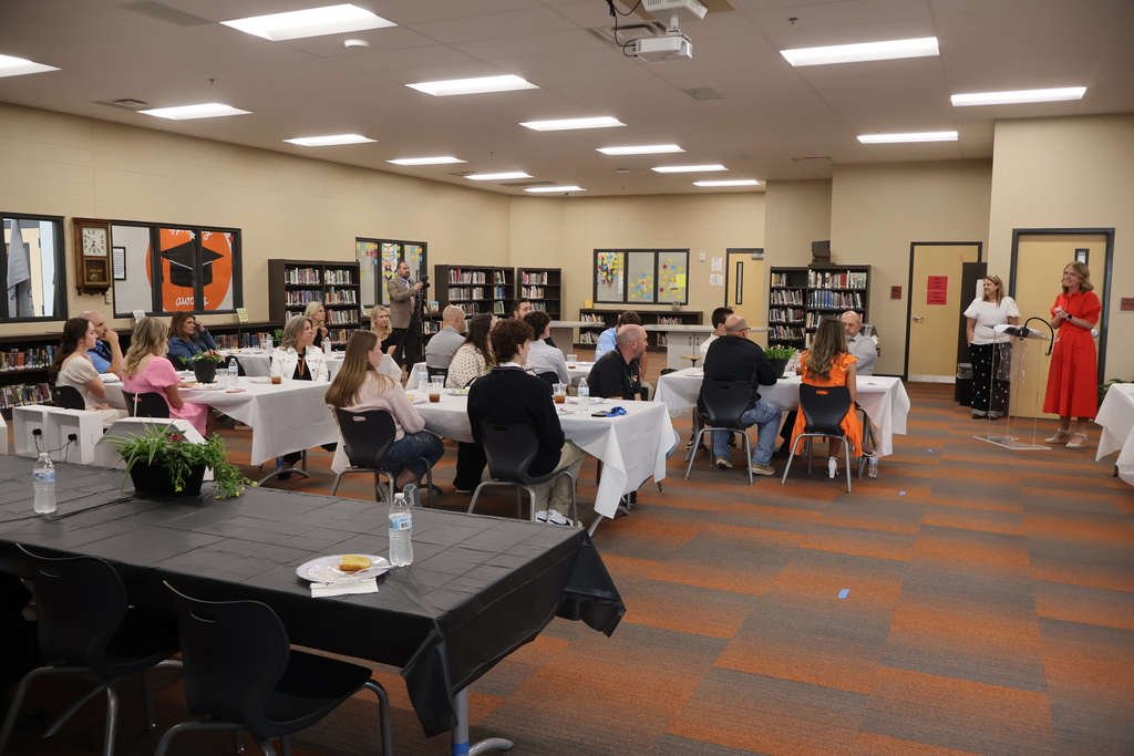 Group photo of everyone attending the luncheon while someone speaks at the podium. 