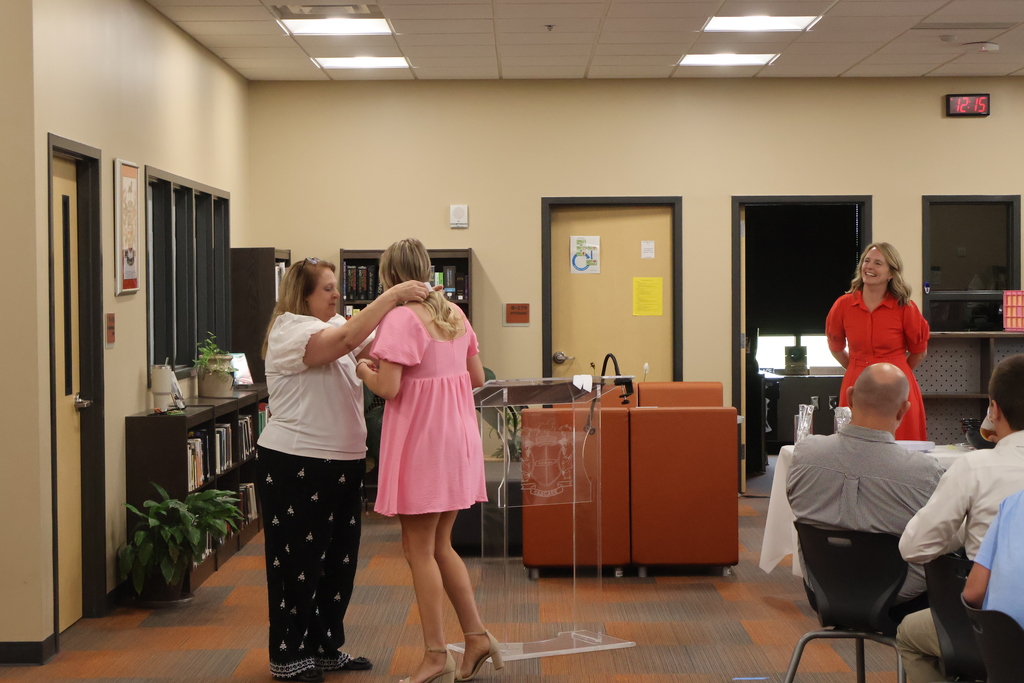 A student receiving a medal from the guidance counselor. 