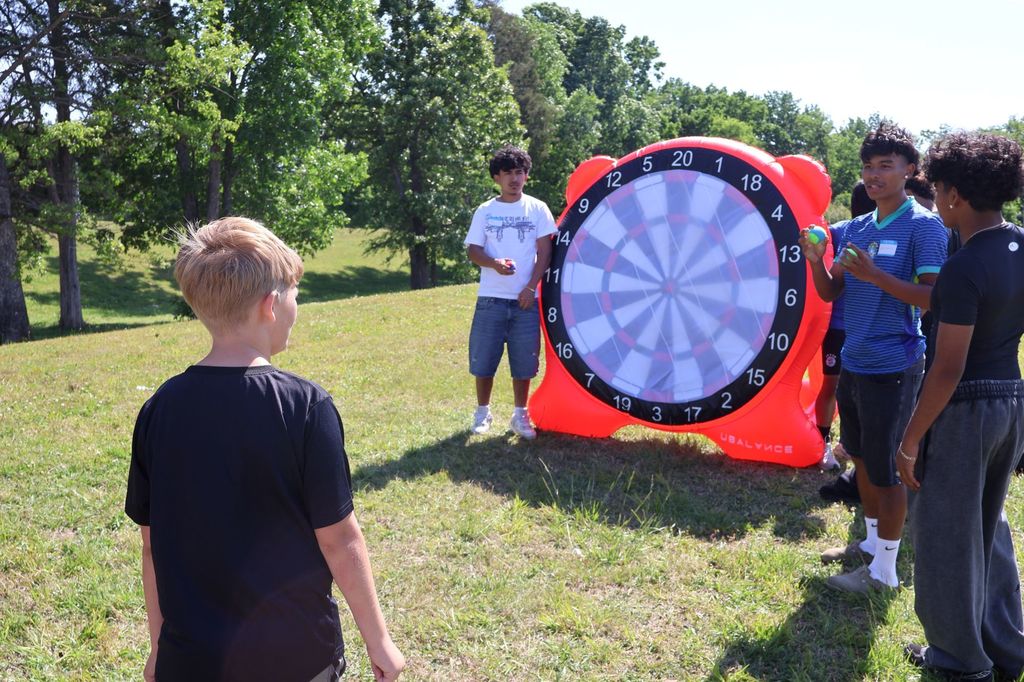 A student is playing a dart game.
