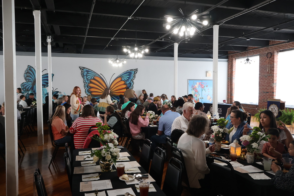People sitting down to eat at tables at the Support Staff of the Year Celebration.