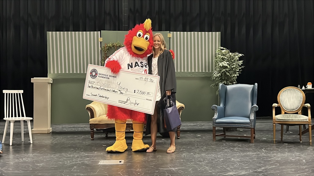 A student from Cascade High School receives a scholarship check from the Nashville Sounds mascot. 
