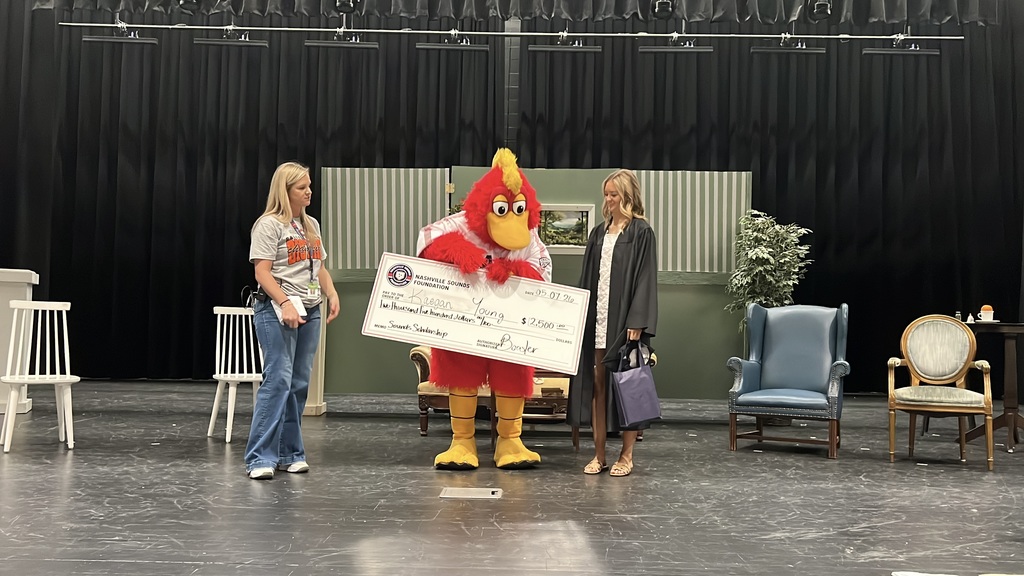 A student from Cascade High School receives a scholarship check from the Nashville Sounds mascot. 