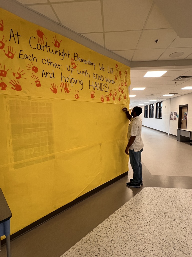The Assistant Principal is writing a message on the banner students made.
