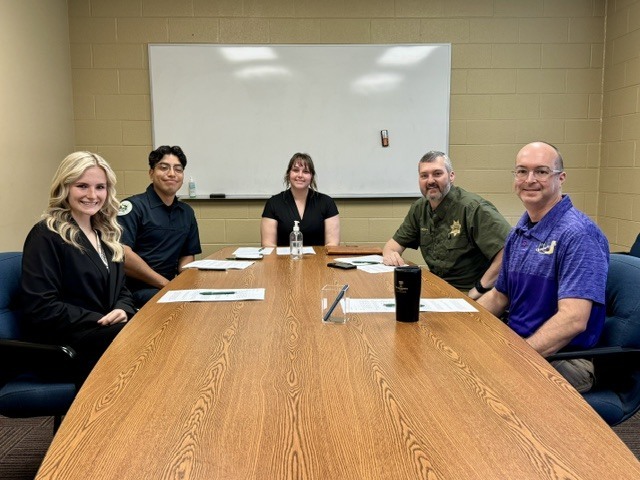 A table with five people who were participating in giving the interviews.