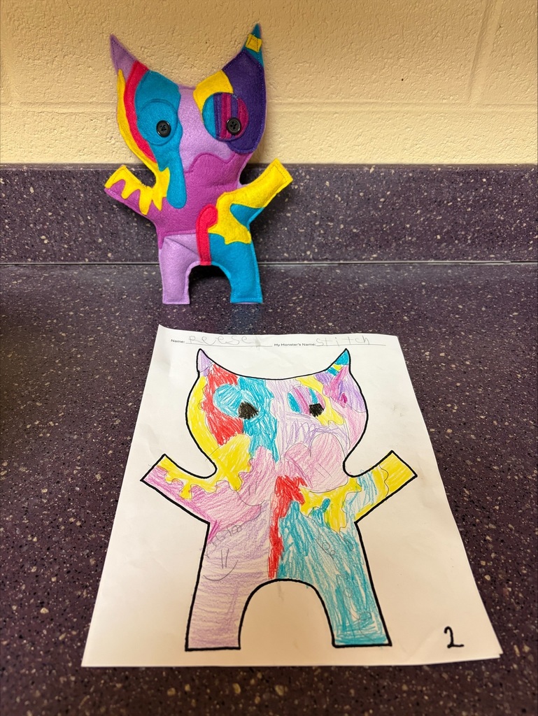 The finished friendly monster is posed behind the drawing of it. 