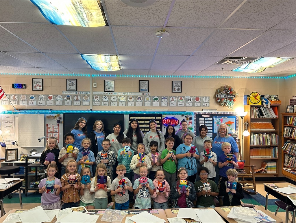 A group picture of the elementary and high school students in the classroom.