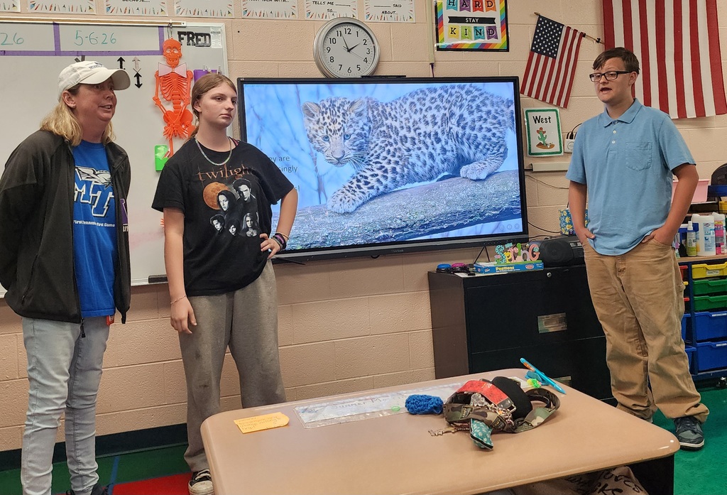 Students are learning an talking about zoo animals with their teacher. 