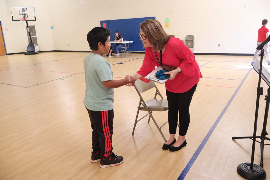 A student shakes a woman's hand at East Side Elementary School's Amazing Shake competition. 