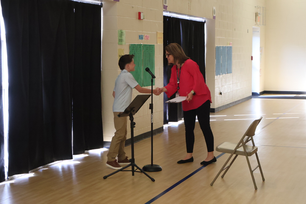 A student shakes a woman's hand at East Side Elementary School's Amazing Shake competition. 