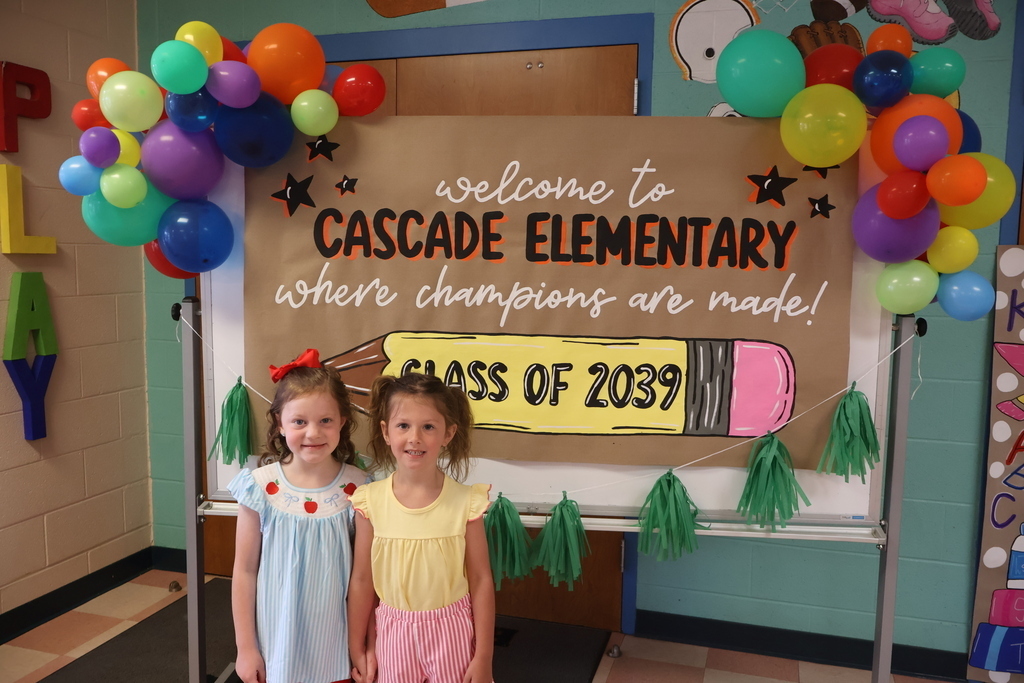 Two students pose in front of a welcome sign for Cascade Elementary School.