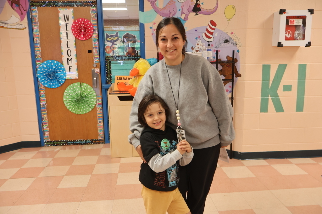A boy and his mom pose for a picture in the hallway.