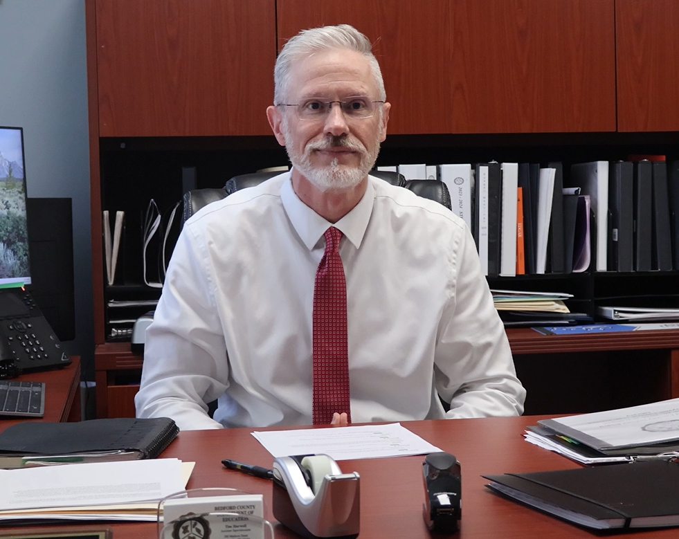 Incoming Superintendent Mr. Tim Harwell in his office sitting at his desk.