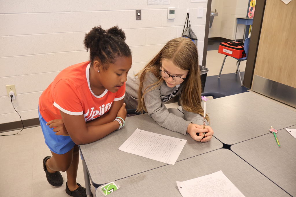 Two students are discussing their project-based learning assignment about kindness.