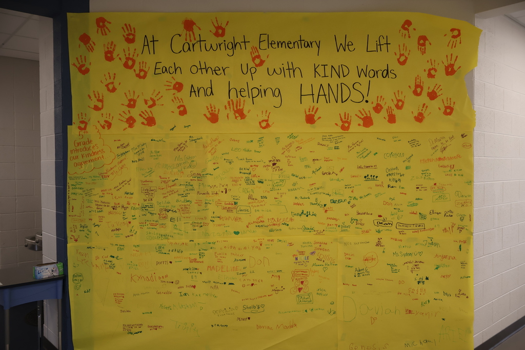 A large yellow paper is on the wall where staff and students have signed it.