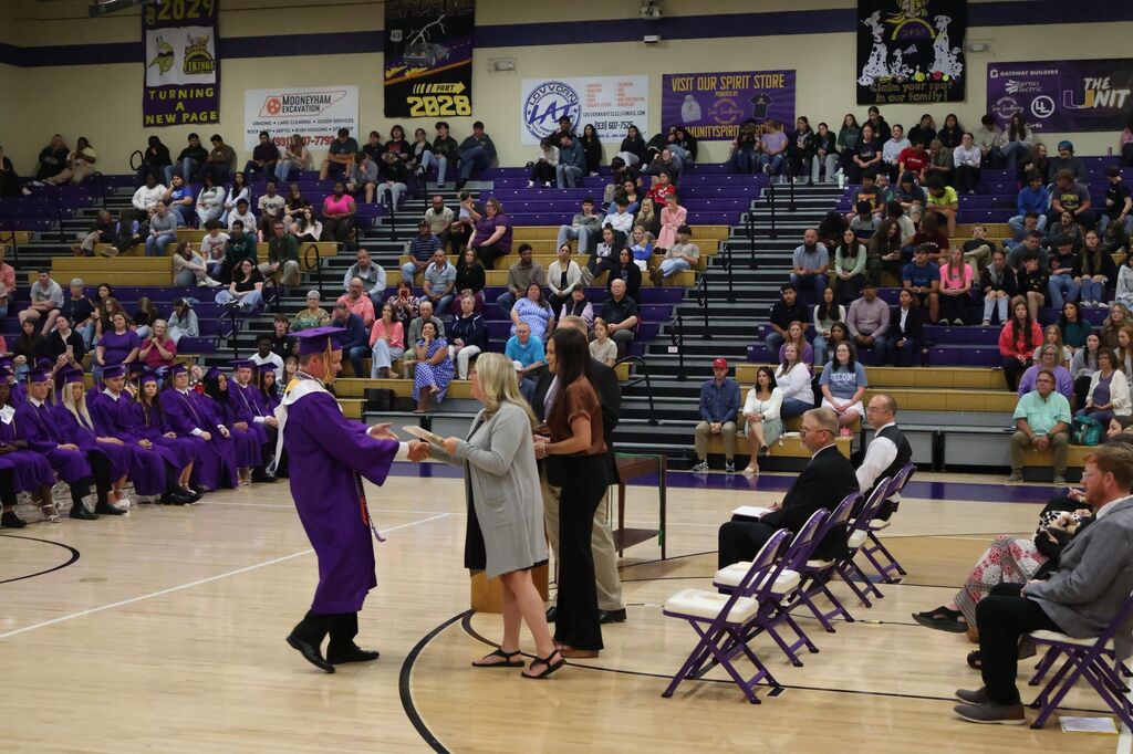A student is shaking hands while receiving an award.
