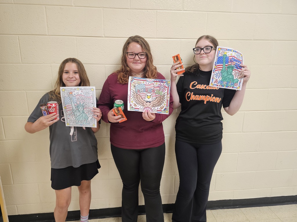 Three students pose for a picture holding their coloring sheets they entered into the coloring contest along with the prizes they earned.