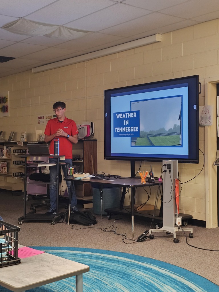 Meteorologist Elijah Kirby is giving a presentation to the class on a large screen.