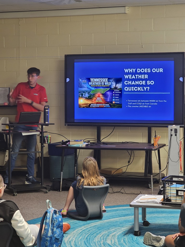 Meteorologist Elijah Kirby is giving a presentation to the class on a large screen.