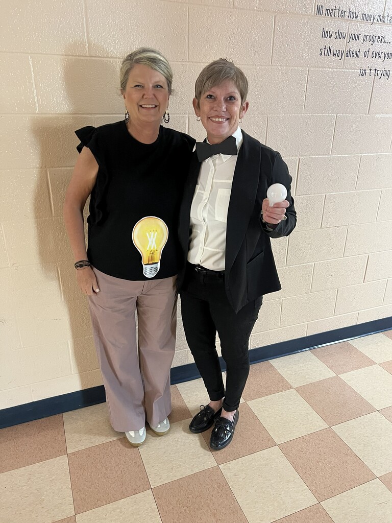 Two teachers are dressed up for dress up day as a lightbulb and Thomas Edison.