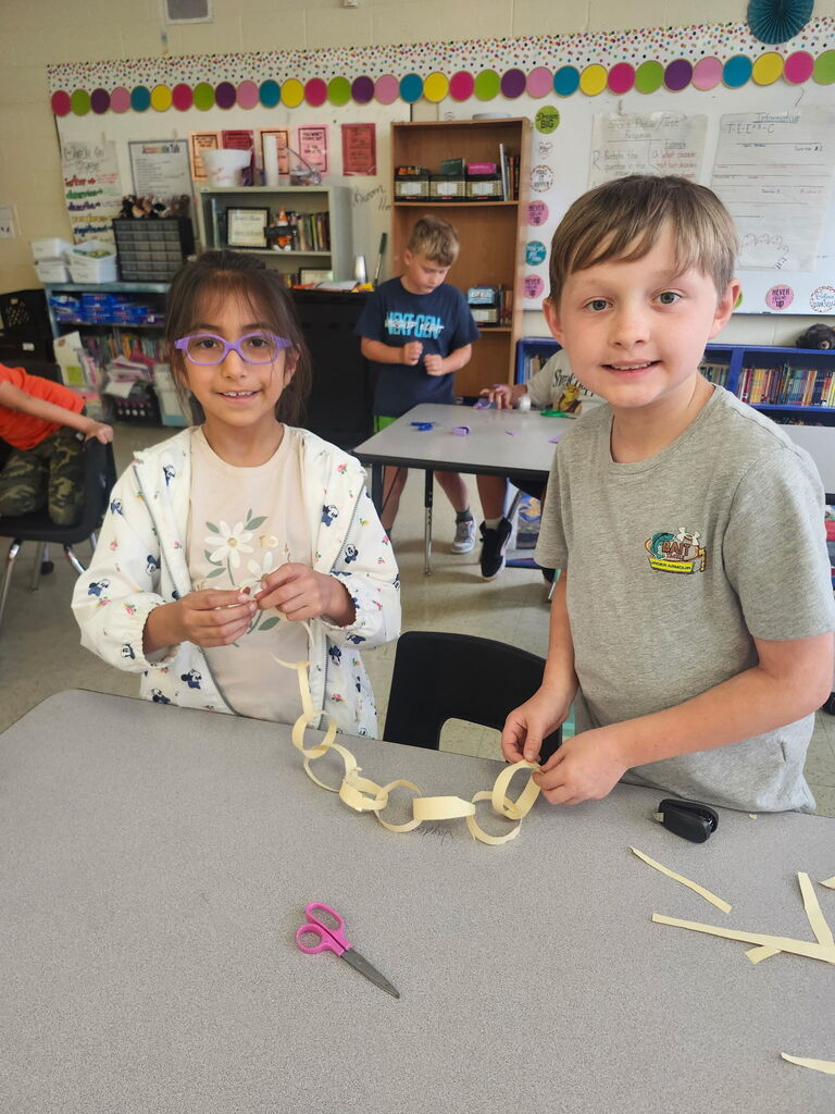 Students are working on putting a paper chain together. 