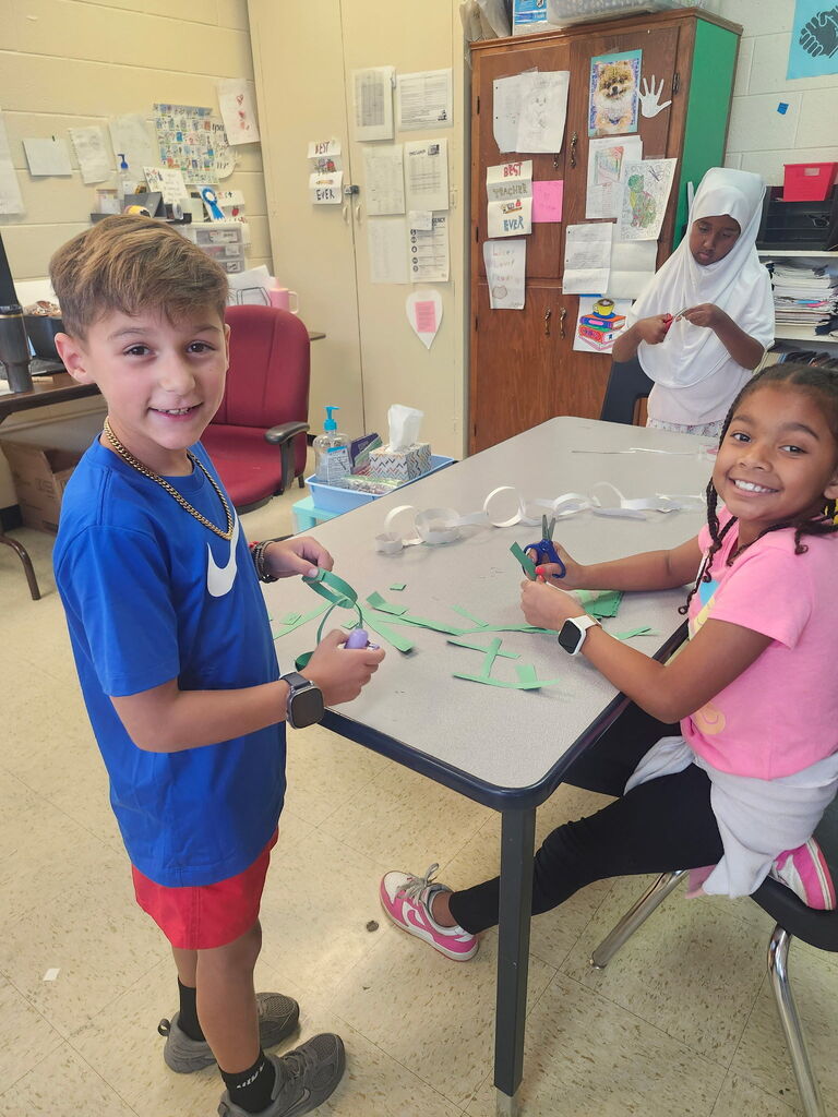 Students are working on putting a paper chain together. 