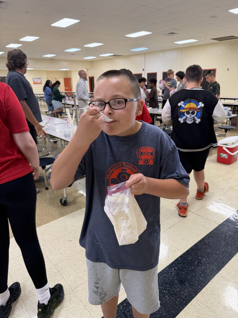 A student is trying out the ice cream that they just made in a bag.