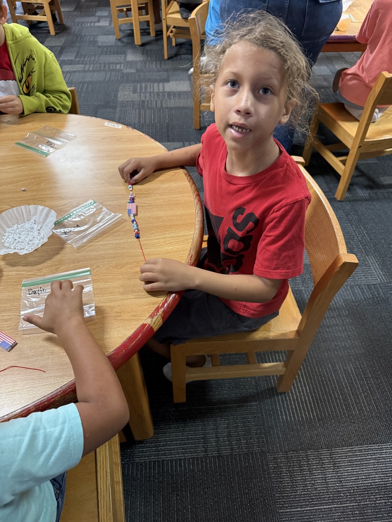 A student is showing off the finished bracelet he made.