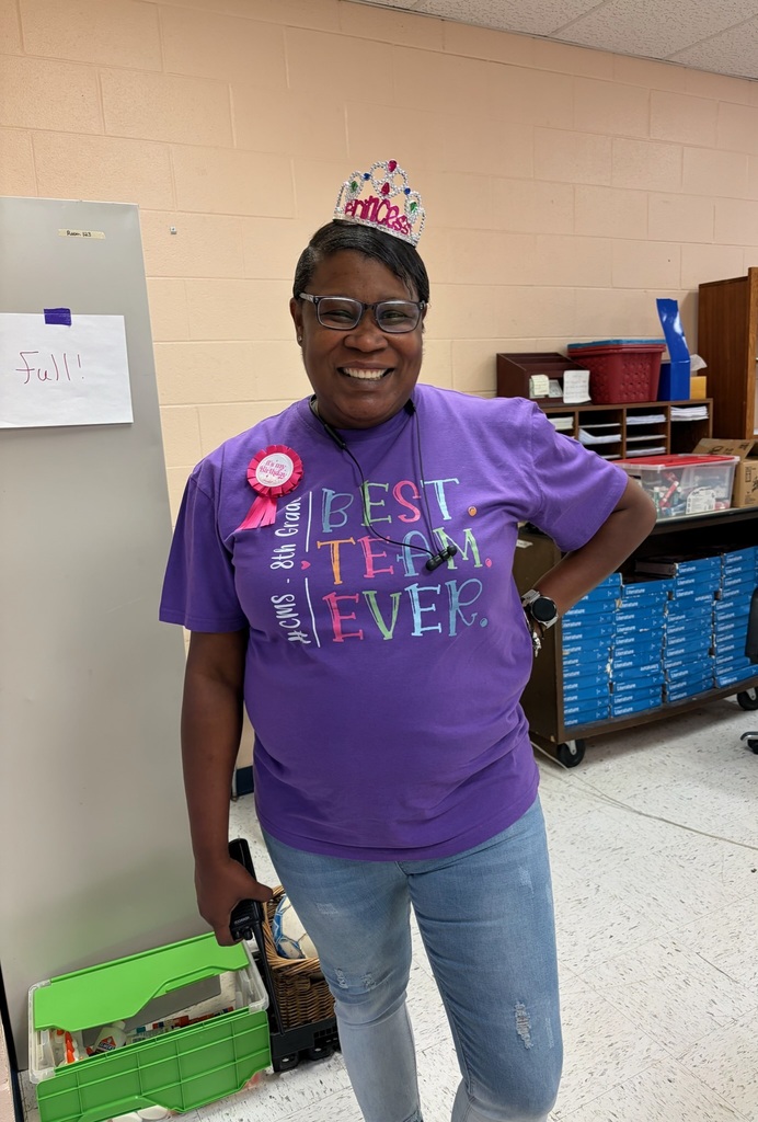 A teacher poses for a picture wearing a crown and ribbon to celebrate her birthday. 