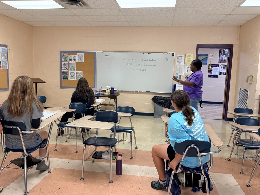 Students and their teacher are playing Wheel of Fortune on the white board. 